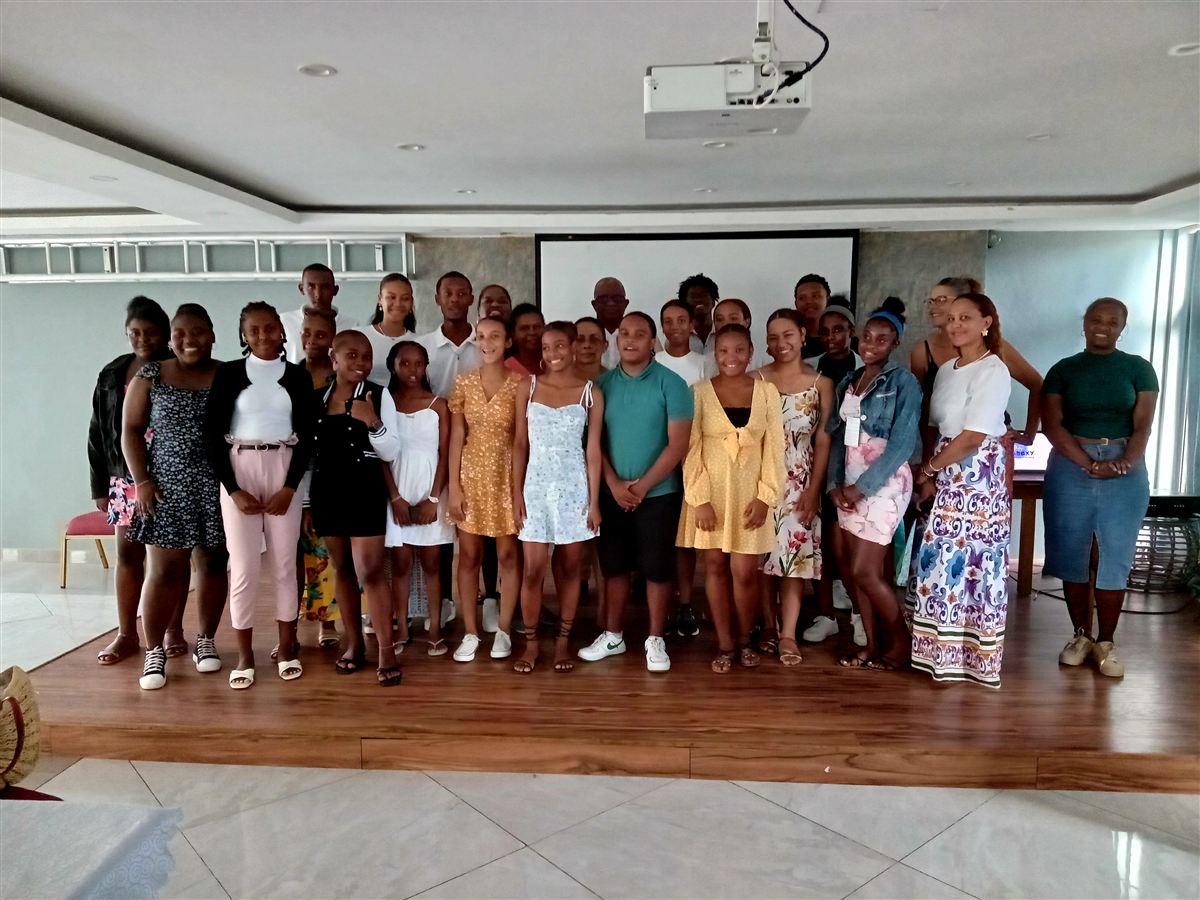 Photo de groupe des ambassadeurs formés à Rodrigues, debout sur une estrade avec l'équipe d'animation, à la fin de la formation
